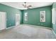 Main bedroom with carpet flooring, a door to the patio, and two windows for natural light at 10318 Piper Dr, New Port Richey, FL 34654