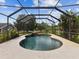 Inviting screened-in pool with a stone waterfall feature, offering a private backyard oasis at 10318 Piper Dr, New Port Richey, FL 34654