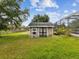 A small, charming storage shed in the backyard, next to the screened-in pool at 10318 Piper Dr, New Port Richey, FL 34654