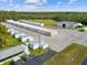 A ground-level view of multiple storage units and a maintenance building with car parking at 10318 Piper Dr, New Port Richey, FL 34654