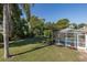 Lush backyard with a screened-in pool enclosure, providing a private and serene outdoor space to relax and enjoy at 10372 Fairchild Rd, Spring Hill, FL 34608