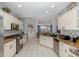 Spacious kitchen with tile floors, granite countertops, white cabinetry, and stainless steel appliances at 10372 Fairchild Rd, Spring Hill, FL 34608