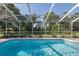 Screened-in pool with a beautiful view of the landscaped backyard at 10372 Fairchild Rd, Spring Hill, FL 34608