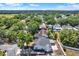 An aerial view of a charming two-story home with a well-maintained yard and mature trees in a quiet neighborhood at 10423 Ashley Oaks Dr, Riverview, FL 33578