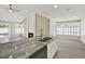 Open kitchen with granite countertops, stainless appliances, and a cozy fireplace at 10423 Ashley Oaks Dr, Riverview, FL 33578