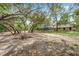 Vast backyard with mature trees provides privacy around a screened-in pool, enhancing the outdoor living experience at 10531 Lakeview Dr, New Port Richey, FL 34654