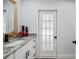 Renovated bathroom with a granite counter, modern fixtures, a framed mirror, and a stylish door at 10531 Lakeview Dr, New Port Richey, FL 34654