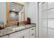 Beautiful bathroom with a granite counter, modern fixtures, a framed mirror, and a stylish door at 10531 Lakeview Dr, New Port Richey, FL 34654