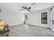 Spacious bedroom featuring two windows, ceiling fan, and gray wood-look tile at 10531 Lakeview Dr, New Port Richey, FL 34654