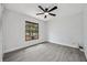 Cozy bedroom featuring wood-look tile floors, a modern ceiling fan, and a window with natural light at 10531 Lakeview Dr, New Port Richey, FL 34654