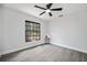 Bright bedroom with grey flooring, ceiling fan, and a large window offering lots of natural light at 10531 Lakeview Dr, New Port Richey, FL 34654