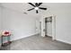 This bedroom features stylish gray floors, a ceiling fan, and a closet, creating a welcoming and functional space at 10531 Lakeview Dr, New Port Richey, FL 34654