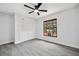 This bedroom features stylish gray floors, a ceiling fan, and a closet, creating a welcoming space at 10531 Lakeview Dr, New Port Richey, FL 34654