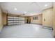 Clean garage with a functional garage door, side door, and a refrigerator for extra storage at 10531 Lakeview Dr, New Port Richey, FL 34654