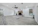 Open-concept living room features gray wood-look tile, brick fireplace, and view to backyard at 10531 Lakeview Dr, New Port Richey, FL 34654