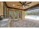 Relaxing covered patio with brick pavers, a ceiling fan, and bar area overlooking the pool at 10531 Lakeview Dr, New Port Richey, FL 34654