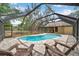 Inviting screened-in pool area featuring a brick patio and comfortable lounge chairs, perfect for relaxation at 10531 Lakeview Dr, New Port Richey, FL 34654