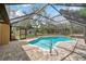 Enclosed pool area featuring a brick patio, clear blue water, and a screened enclosure at 10531 Lakeview Dr, New Port Richey, FL 34654