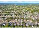 Aerial view of a neighborhood showcasing tree-lined streets and a lake in the distance at 1054 Embassy Ave, Spring Hill, FL 34606