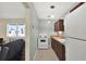 Galley kitchen with white appliances and wooden cabinets offering efficient space at 1054 Embassy Ave, Spring Hill, FL 34606