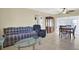 Bright living room featuring tile floors, a ceiling fan, and a dining area with backyard access at 1054 Embassy Ave, Spring Hill, FL 34606
