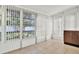 Enclosed sunroom featuring neutral tile flooring, bright natural light, and vertical blinds for privacy at 1054 Embassy Ave, Spring Hill, FL 34606