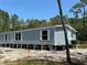 Side view of a home, showing the light blue siding and white trim at 11444 Lake Dr, New Port Richey, FL 34654