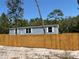 Charming single-story home with light blue siding and a newly installed wooden fence at 11444 Lake Dr, New Port Richey, FL 34654
