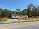 Home featuring light blue siding, white trim, and a newly installed wooden fence at 11444 Lake Dr, New Port Richey, FL 34654