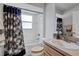 Bright bathroom features a shower and tub combo, patterned shower curtain, and a wood vanity at 12004 Valley Falls Loop, Spring Hill, FL 34609