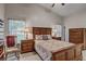 Spacious bedroom features vaulted ceilings, ceiling fan, two windows and wooden furniture at 12004 Valley Falls Loop, Spring Hill, FL 34609