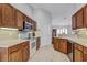 Kitchen featuring wood cabinets and modern appliances with an open layout and access to more rooms at 12004 Valley Falls Loop, Spring Hill, FL 34609