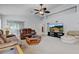 Comfortable living room with leather sofas, ceiling fan and view to the backyard through large glass sliding doors at 12004 Valley Falls Loop, Spring Hill, FL 34609