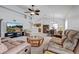 Open-concept living room with tile flooring, brown sofas, providing ample space for entertaining at 12004 Valley Falls Loop, Spring Hill, FL 34609