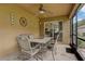 Enclosed patio with tile flooring, ceiling fan and an outdoor dining set for al fresco dining at 12004 Valley Falls Loop, Spring Hill, FL 34609