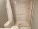Bright bathroom with floral-accented tiles, shower, and toilet features grab bar for accessibility at 12119 Sunny Glen Ln # G2, Hudson, FL 34669