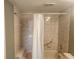 Tiled bathroom with shower-tub combination, neutral tile and safety bar at 12119 Sunny Glen Ln # G2, Hudson, FL 34669