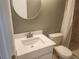 Bathroom featuring a toilet, vanity, and round mirror at 12119 Sunny Glen Ln # G2, Hudson, FL 34669
