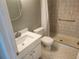 Bathroom featuring a tiled shower, toilet, vanity, and a round mirror at 12119 Sunny Glen Ln # G2, Hudson, FL 34669