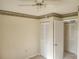 Bedroom with tile flooring, ceiling fan, and closet with bi-fold doors at 12119 Sunny Glen Ln # G2, Hudson, FL 34669