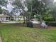 A community grill and picnic benches are nestled beneath mature trees in a grassy area at 12119 Sunny Glen Ln # G2, Hudson, FL 34669