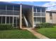 Condo exterior shows walkway, stairs, and tan paint scheme at 12119 Sunny Glen Ln # G2, Hudson, FL 34669