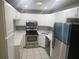 Well-lit kitchen with white cabinets, stainless steel appliances and white tile flooring at 12119 Sunny Glen Ln # G2, Hudson, FL 34669