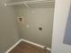 Laundry room with connections, upper shelf, and wood-look flooring at 12119 Sunny Glen Ln # G2, Hudson, FL 34669