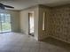 Open living room with a ceiling fan, slider access to the screened in patio and outdoor view at 12119 Sunny Glen Ln # G2, Hudson, FL 34669
