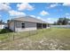 A view of the backyard, highlighting the home's exterior paint and fenced yard at 12848 Hilary St, Spring Hill, FL 34609