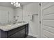 Bathroom featuring a dark vanity with granite countertop and decorative mirror and light fixture at 12848 Hilary St, Spring Hill, FL 34609