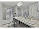 Bright bathroom with double sinks, granite countertop, and a tub/shower combo with a checkered curtain at 12848 Hilary St, Spring Hill, FL 34609