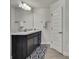 Bathroom featuring a dark vanity with granite countertop and decorative mirror and light fixture at 12848 Hilary St, Spring Hill, FL 34609
