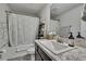 Bathroom features a shower with a patterned curtain, decorative shelves, and a large vanity at 12848 Hilary St, Spring Hill, FL 34609